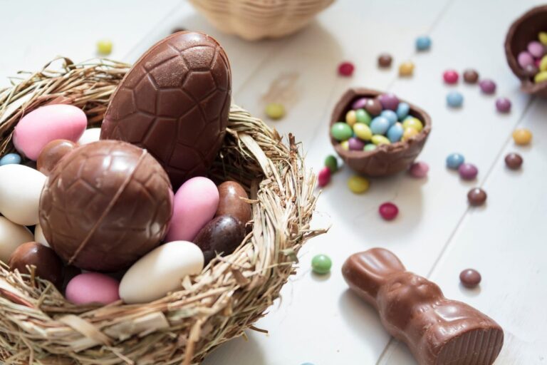 Gráfico de precios de productos de la canasta de Semana Santa en una mesa con alimentos típicos.