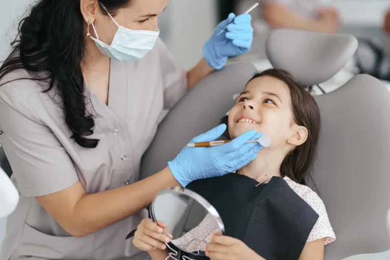 Niño pequeño cepillándose los dientes con supervisión de un adulto