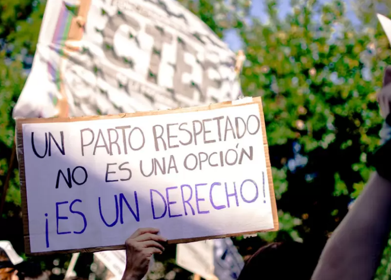 Mujer embarazada en consulta médica con expresión seria