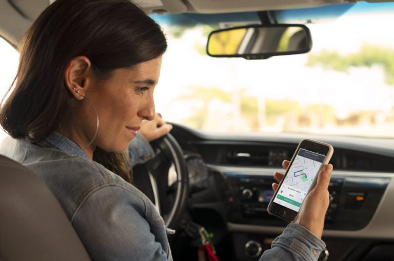 Mujer usando la aplicación de Uber en un teléfono móvil